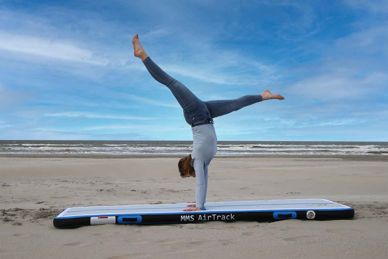 MMS AirTrack oefenmat op het strand met gymnast die handstand uitvoert